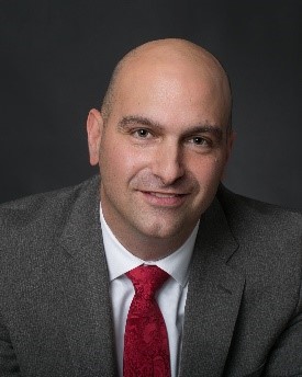 A person in a suit and tieDescription automatically generated with medium confidence